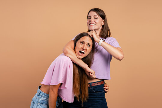 Women playfully fighting having fun together