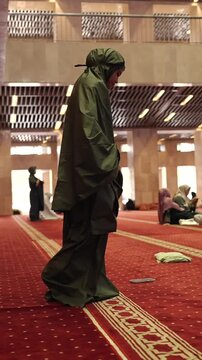 Muslim woman performing salah prayer in mosque