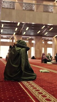 Muslim woman praying inside modern mosque