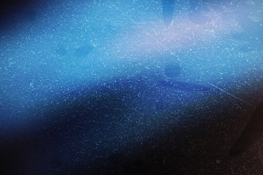 Abstract dark blue background with a subtle radial light effect and a fine, scattered white dust or scratch texture overlay