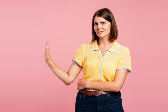Woman signaling stop gesture with a serious expression