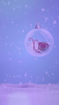 Animation of snow falling over christmas baubles in winter scenery