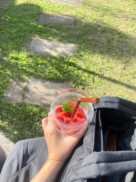 young woman holding a glass of fresh watermelon juice