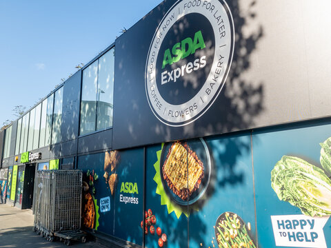 London. UK- August 25. 2026. The company name sign and advertisement on the facade of a branch of Asda Express grocery supermarket.