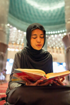 Muslim woman reading holy book in mosque