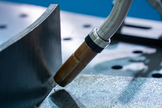 Close-up of industrial welding torch working on metal workpiece
