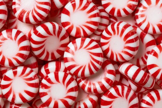 Colorful peppermint candies are arranged closely together on a flat surface creating a festive look