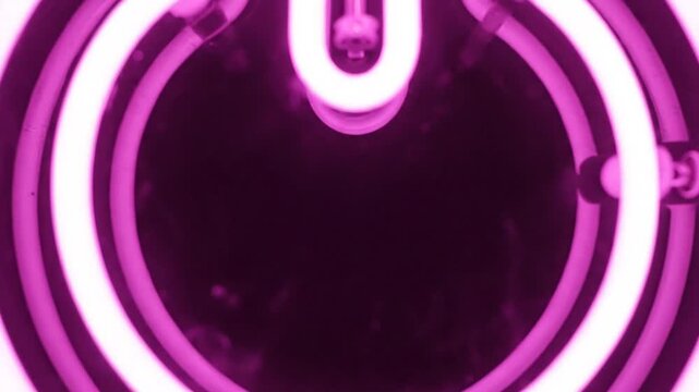 Glowing pink neon power symbol on dark background