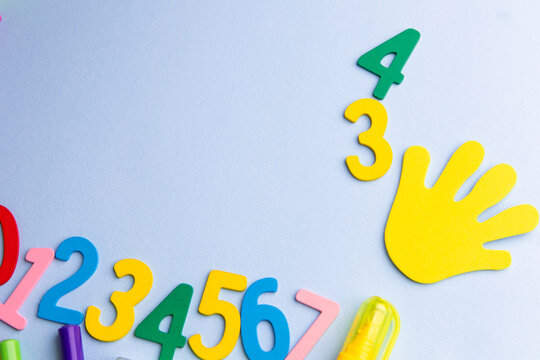 Kids preparing for back to school with colorful numbers and a handprint on a light surface, Copy Space
