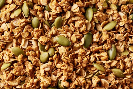Granola with oats and pumpkin seeds in a large mixture ready for serving