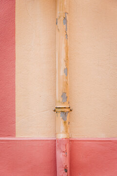 Pink and cream wall with a descending gutter. Graphic wall