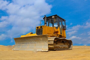 bulldozer with yellow color, on construction site and sky background © faiz
