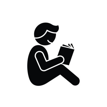 Silhouette of a person reading a book attentively.