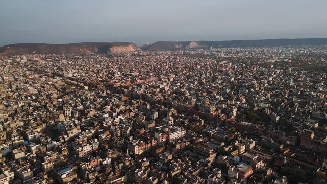 Aerial view of jaipur, the pink city of india. Densely packed buildings and urban sprawl under a hazy sky at sunset