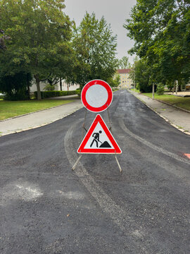 Construction Site Sign on a Newly Renovated Asphalt Road &ndash; Fresh Pavement and Roadworks Safety Concept Vertical