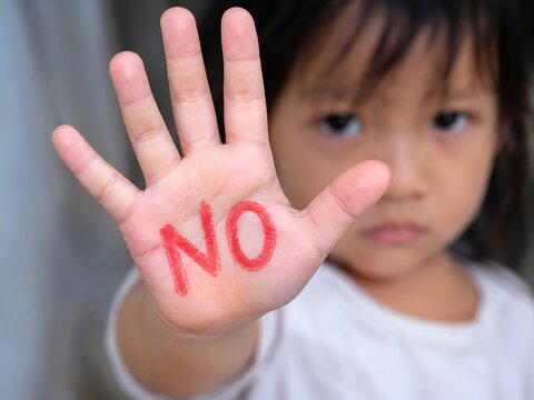 Young Child Showing Hand with NO Message on Palm. For child safety, anti bullying, personal boundaries, consent, communication, and saying no. Protest, refusal, child protection, personal boundaries
