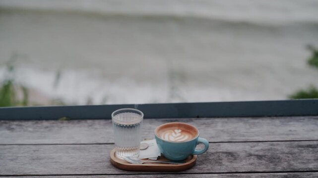 Relaxing morning scene with a white cup of coffee on a balcony overlooking the stunning sea view of Thailand.