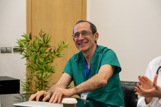 Medical professional in scrubs smiling while attending a healthcare meeting