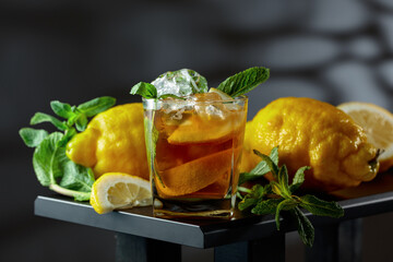 Iced black tea with lemon wedges, ice cubes and mint leaves. © Igor Normann