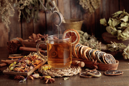 Cup of herbal tea with various dried herbs, flowers, and spices.