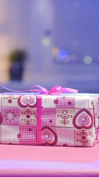 Gift wrapped in Christmas paper with red ribbon