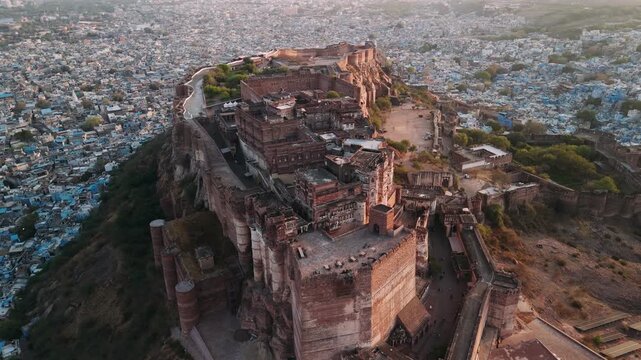 Aerial view of mehrangarh fort towering above the blue city of jodhpur, india during a beautiful sunrise