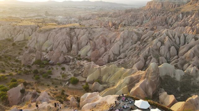 Cinematic aerial drone footage of Cappadocia&rsquo;s spectacular rock formations and fairy chimneys at sunset, bathed in warm golden light, showcasing the unique volcanic landscape of central Turkey.