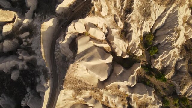 Cinematic aerial drone footage of Cappadocia&rsquo;s spectacular rock formations and fairy chimneys at sunset, bathed in warm golden light, showcasing the unique volcanic landscape of central Turkey.
