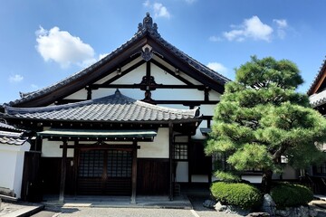 Fototapeta premium Traditional Temple Facade and Pine Tree Beneath a Clear Blue Sky