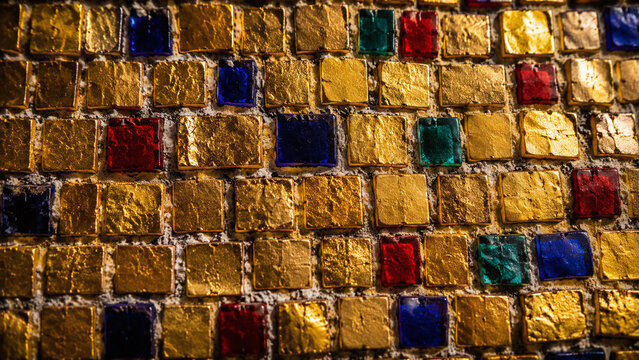 Byzantine mosaic gold smalti tesserae macro with vivid 24-karat gold leaf glass tiles blue red green accent tesserae and lime mortar grout on black background