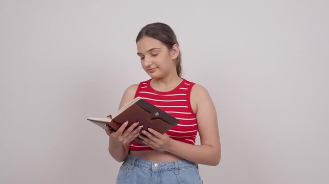 Indian Teenage Girl Opening Notebook and Reading