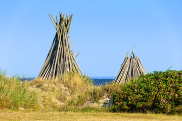Wooden teepee structures on coastal dunes of Hvide Sande © Taljat
