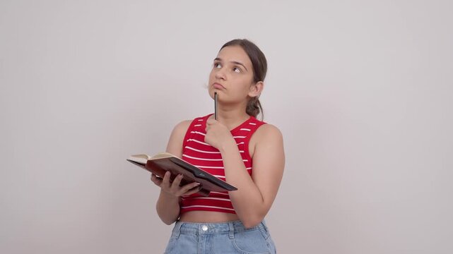 Indian Teenage Girl Thinking and Writing in Notebook