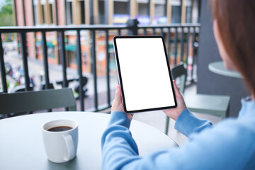Mockup image of a woman holding digital tablet with blank white desktop screen in cafe © Farknot Architect