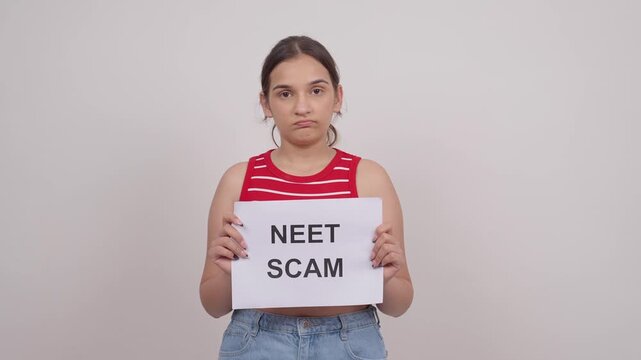 Disappointed Indian Teenage Girl Holding NEET SCAM Poster