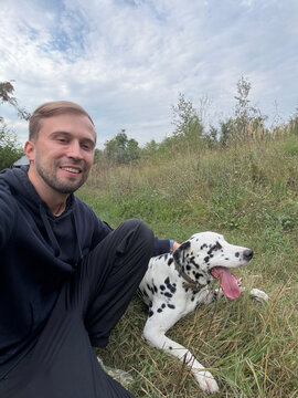 Happy Man Taking Selfie With Dalmatian Dog Outdoors In Countryside Field