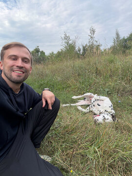 Happy Man Taking Selfie With Dalmatian Dog Outdoors In Countryside Field