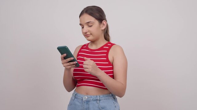 Happy Indian Teenage Girl Scrolling on Socail Media and Smiling 
