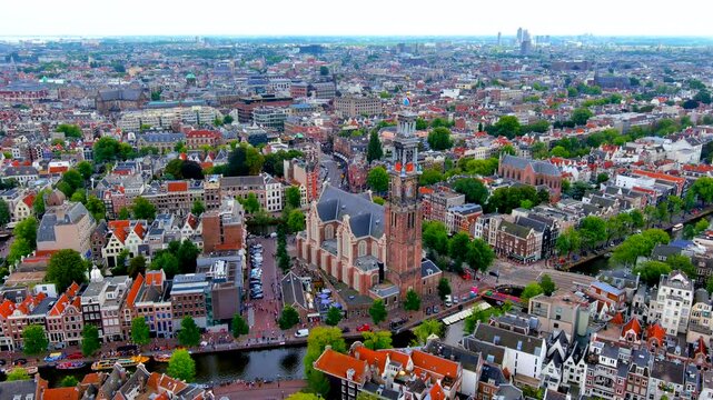 Aerial drone view of the Westerkerk church and Westertoren with visitors queuing at the Anne Frank House on the Prinsengracht canal, Amsterdam, Netherlands, in summer.