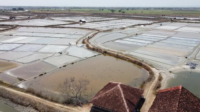 Salt farming, harvesting the white gold. Beautiful salt pans of Rembang, Indonesia.