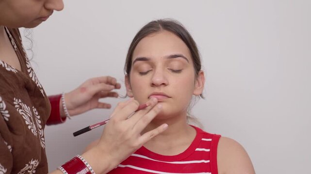 Makeup Artist Applying Lip Liner on Model's Lips