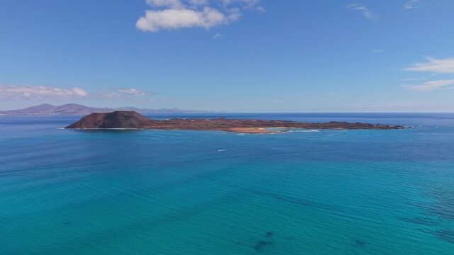 Areal views of Lobos Island, a small, uninhabited volcanic nature reserve with crescent-shaped white sand beach with crystal-clear turquoise waters located in Fuerteventura, Canary Islands, Spain.