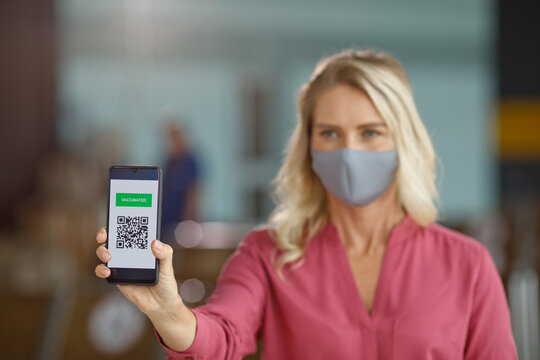 A woman displays her digital vaccination certificate on a smartphone, demonstrating proof of immunization for public health protocols