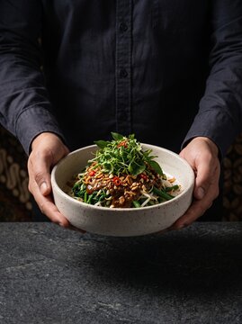 Pecel Jawa. Pecel Jawa sayur bumbu kacang. Indonesian Javanese Pecel by Man. Pecel Jawa Mangkuk. Man Holding Authentic Javanese Pecel Rice with Vegetable Salad and Peanut Sauce in Bowl with Dark Moody