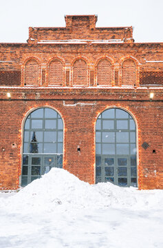 Snowy brick facade with arched entrance and festive lights
