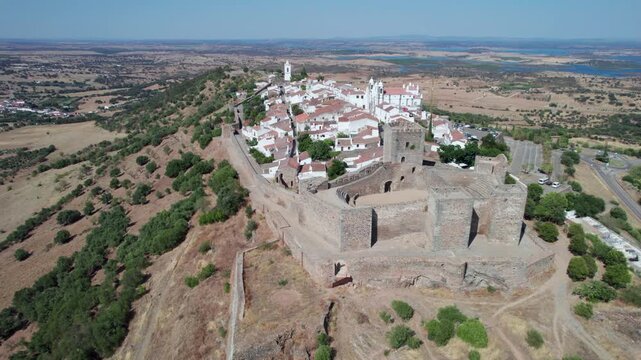 Stunning aerial footage showing the historic medieval walled village of Monsaraz in Alentejo, Portugal, overlooking the scenic landscape