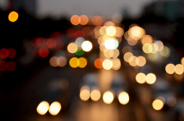 Fototapeta premium A background of beautiful, out-of-focus vehicle lights on a city street, set against the darkness of night traffic.