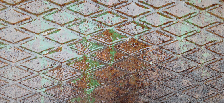 Rusty diamond plate metal texture with weathered green paint