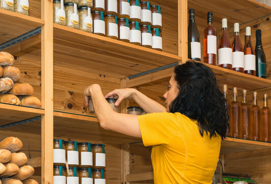 Woman arranging products on shelves in a grocery store