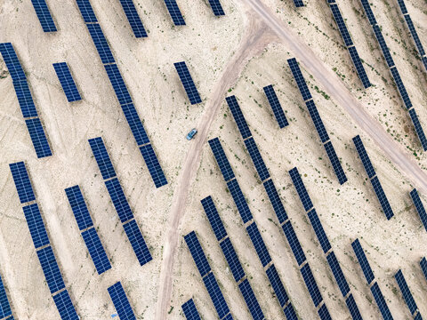 Aerial view of solar panels arranged in rows in the desert